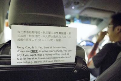 HONG KONG.
SCHOOL BUS FEATURE:
A sign in the back of an Uber driver's car shows that any donations and money given will go to helping fund his role in being part of the 'school bus' system.
'School Buses', are the collective name to a group of volunteers, including Chen, who offer free transport for people who need help getting away from the protests safely. 