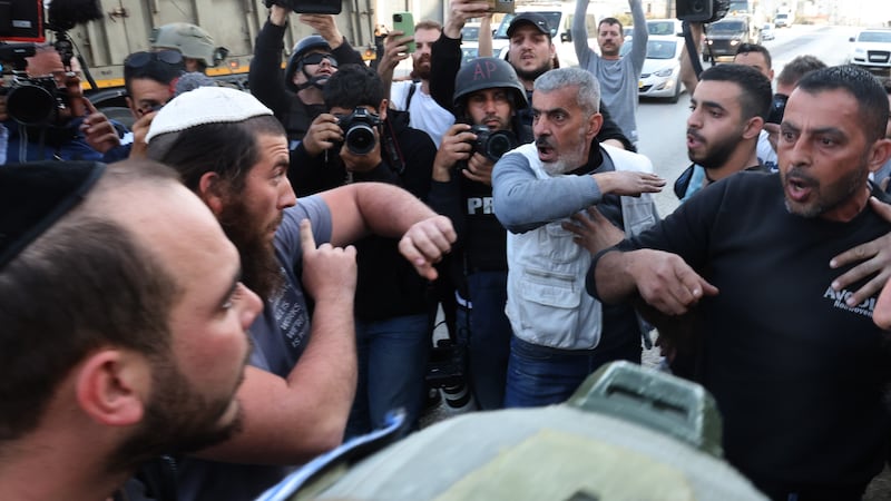 Palestinians argue with Israeli settlers a day after a shooting attack and violence in the West Bank town of Hawara. EPA 