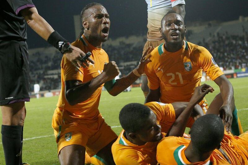 Didier Drogba, left, and his Ivory Coast teammates celebrate after their sides goal on Saturday. Abdeljalil Bounhar / AP
