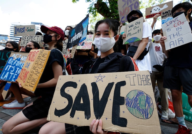 Activists hold signs during a climate change strike in Bangkok, Thailand. EPA