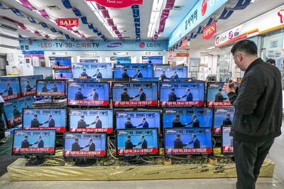 A man watches television screens, showing a broadcast of Kim Jong Un, North Korea's leader, left, and Moon Jae-in, South Korea's president shaking hands during a meeting in Panmunjeom prior to the summit, at Yongsan Electronic Market in Seoul, South Korea, on Friday, April 27, 2018. Kim on Friday became the first North Korean leader to enter South Korea since the peninsula was divided almost seven decades ago as talks begin over dismantling his nuclear weapons program. Photographer: Jean Chung/Bloomberg