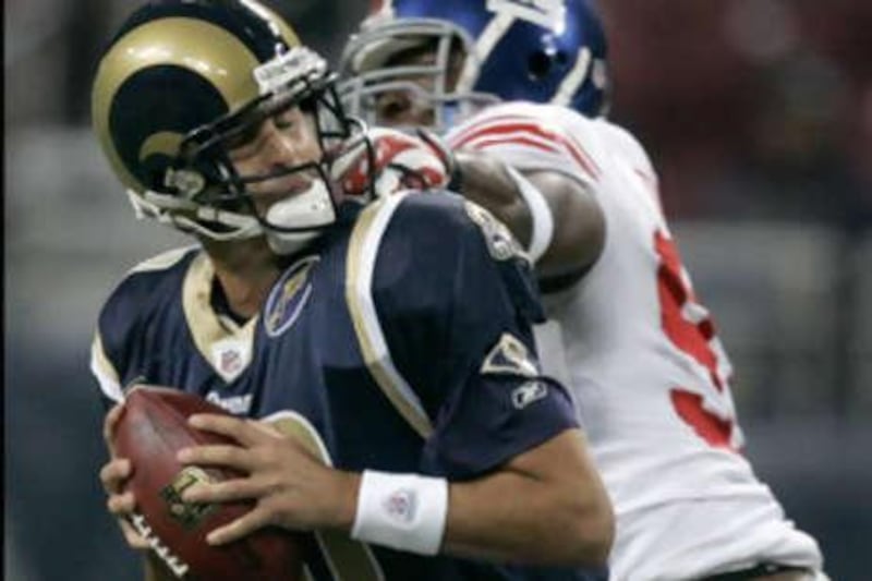 The Rams quarterback Marc Bulger shields the ball from the New York Giants' defensive end Justin Tuck during their defeat.