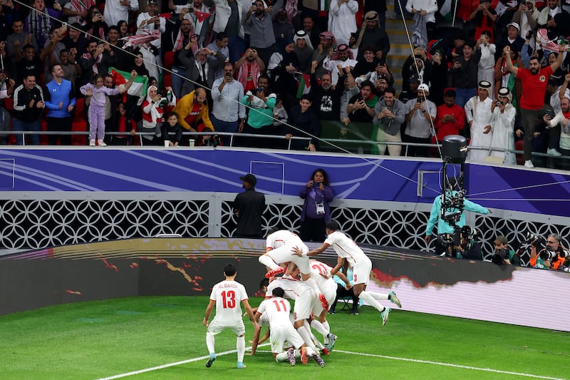 Musa Al Taamari of Jordan is mobbed by teammates after scoring their second goal. Getty Images