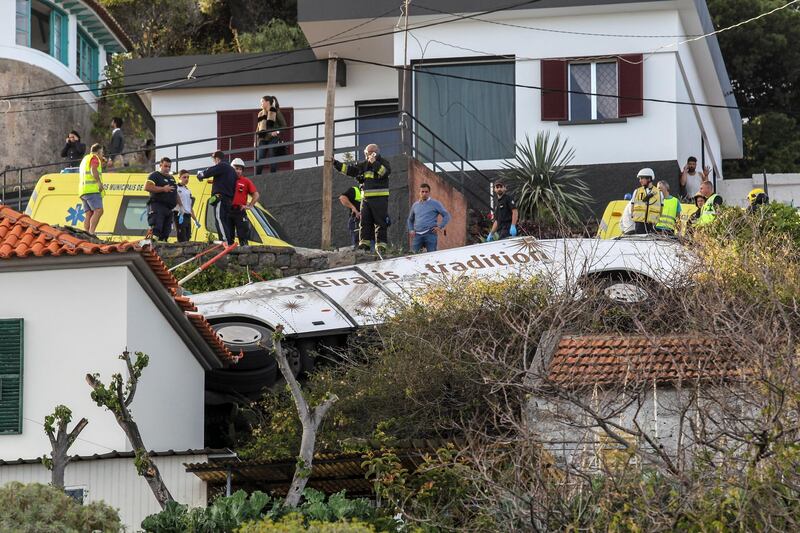 epa07512749 Emergency services inspect the scene of a tourist bus crash in Canico, Santa Cruz, Madeira Island, Portugal, 17 April 2019. According the Civil Protection of Madeira, several people died in the accident.  EPA/HOMEM GOUVEIA