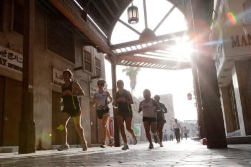 Ian Browning, Carol Pollock, Kirsten Fleming, Judy Marinau, Ester Staples Running through the shade of the textile souk during the early morning summer sunshine when temperatures are more bearable. The Dubai Creek Striders running group, Dubai. 1st July 2011. Duncan Chard for the National