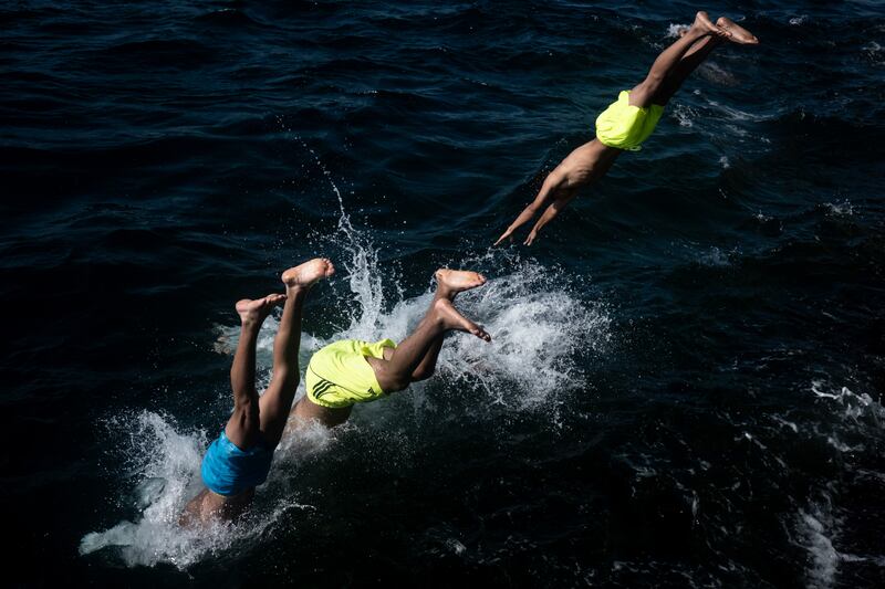 Boys dive into the Bosphorus as temperatures rise above 30°C in Istanbul, Turkey. Getty