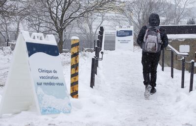 A pedestrian walks past signs for a COVID-19 vaccination clinic in Montreal, Quebec, Canada, on Thursday, Jan. 21, 2021. Even though Canada has secured more vaccines per capita than any other nation, "it doesn't mean much" when the bulk is not yet being delivered, an epidemiologist at the University of Toronto said. Photographer: Christinne Muschi/Bloomberg