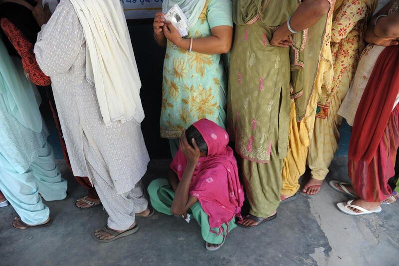 An Indian voter rests in the queue prior to casting her ballot at a polling station near Attari village, about 35 kms from Amritsar. Narinder Nanu / AFP