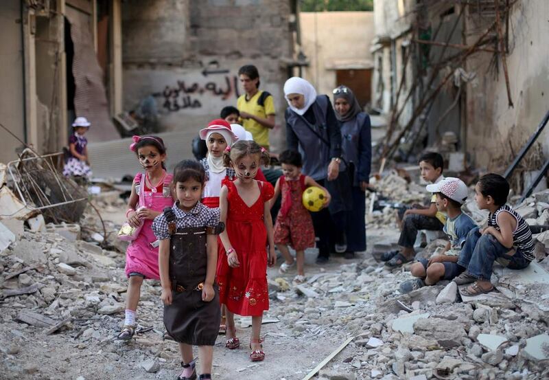 Syrian children walk amid destruction on the outskirts of Damascus ahead of the Eid Al Fitr holiday. Amer Al Mohibany / AFP