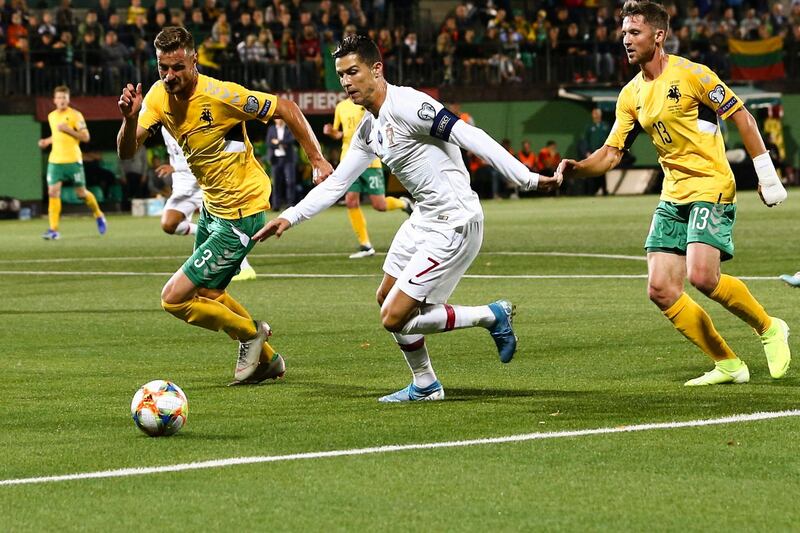 Lithuania's Palionis and Miloliunas fight for the ball with Cristiano Ronaldo of Portugal. epa