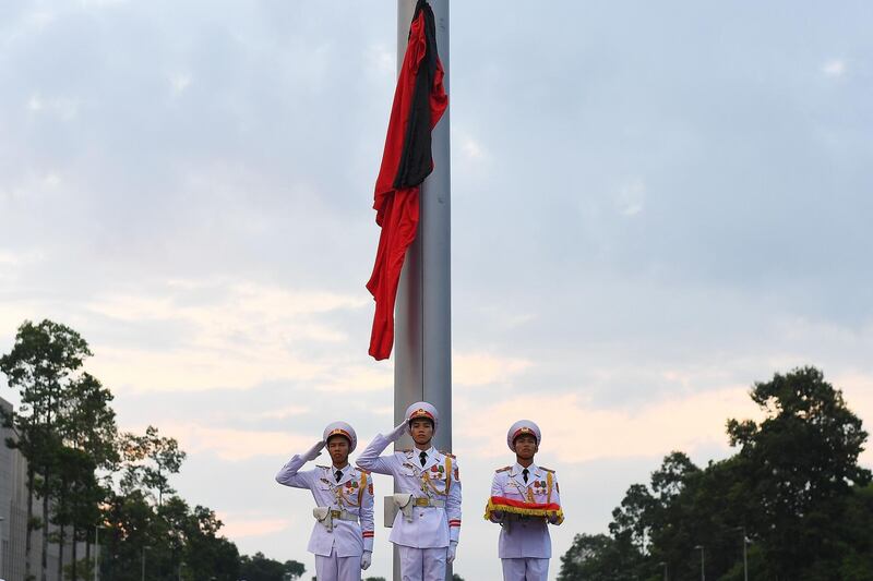 Vietnamese soldiers salute after raising the national flag draped with a black cloth to pay their respect to late President Tran Dai Quang in Hanoi. Manan Vatsyayana/AFP