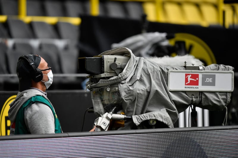 A TV cameraman wears a face mask during the match between Borussia Dortmund and Schalke. AP
