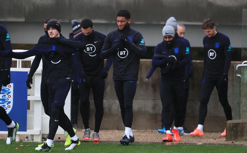 Joe Gomez, centre, walks onto the training pitch with England teammates at St George's Park. PA