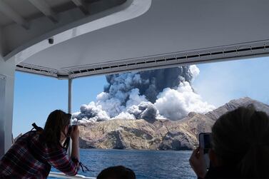 People capturing the eruption of  the volcano on White Island. AFP