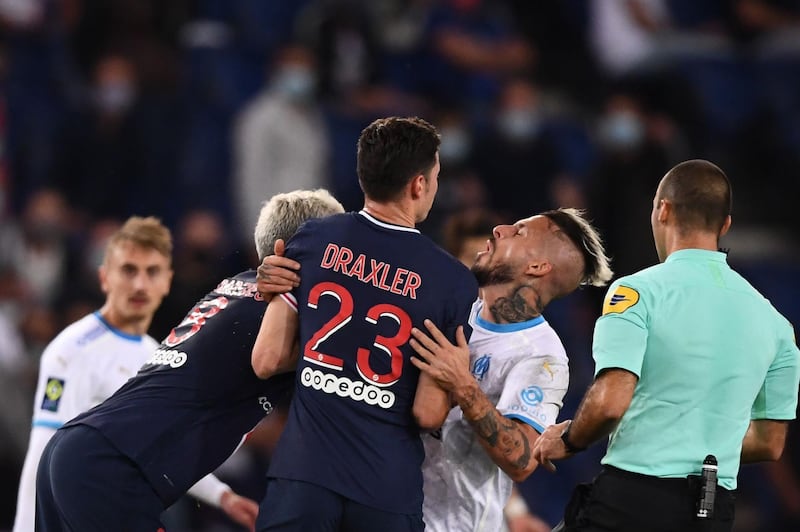 Paris Saint-Germain midfielder Leandro Paredes, left, clashes with Marseille forward Dario Benedetto. AFP