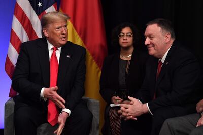 US President Donald Trump (L) speaks to US Secretary of State Mike Pompeo after a bilateral meeting with German Chancellor Angela Merkel on the sidelines of the NATO summit at the Grove hotel in Watford, northeast of London on December 4, 2019. / AFP / Nicholas Kamm
