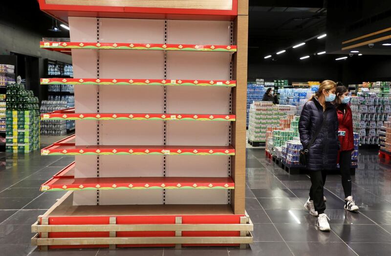 Shoppers walk past an empty shelf at a supermarket in Beirut, Lebanon March 16, 2021. Picture taken March 16, 2021. REUTERS/Mohamed Azakir