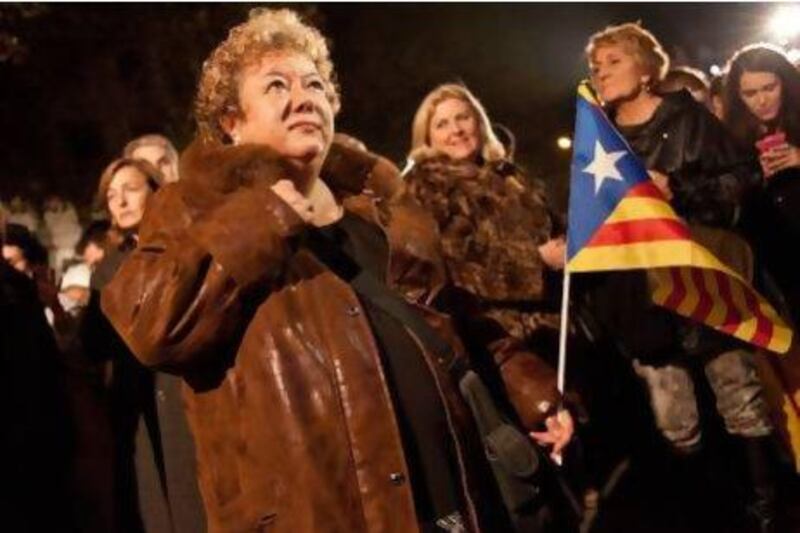 Supporters of Artur Mas's independentist Ciu Party watch the results of the Catalan regional election on a big screen outside the Hotel Majestic in Barcelona. CiU secured fewer seats than expected, and lost many it had previously held. Dave Stelfox for The National