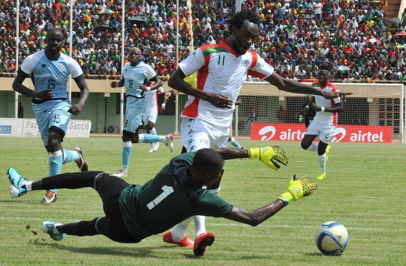 Burkina Faso's Jonathan Pitroipa fights for the ball with Botswana goalkeeper Dembe Kabelo. Ahmed Ouoba / AFP