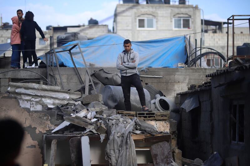 Palestinians surrounded by destroyed buildings after an Israeli air strike in a residential district of the Al Shaboura refugee camp in Rafah, southern Gaza. Bloomberg