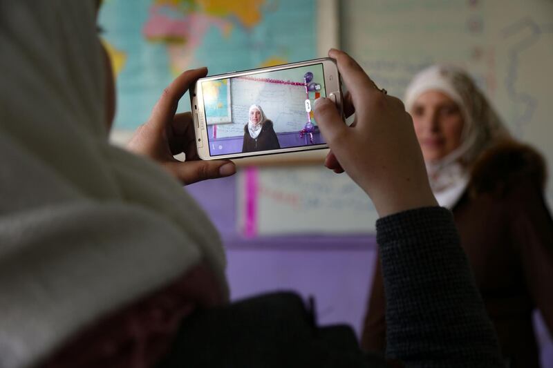 A colleague records a lesson in an empty classroom by geography teacher Danielle Dbeis, to be broadcast for distance learning, amid the coronavirus pandemic,in the rebel-held northwestern Syrian city of Idlib. AFP