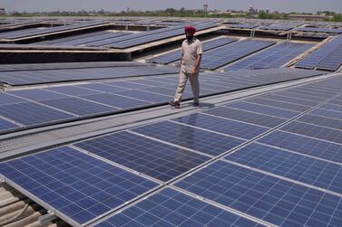 An Indian security officer walks over rooftops covered in solar panels at a solar photovoltaic power plant near Amritsar. Per capita power consumption in India is barely one-tenth of that in the US, offering plenty of scope for future growth. AFP 