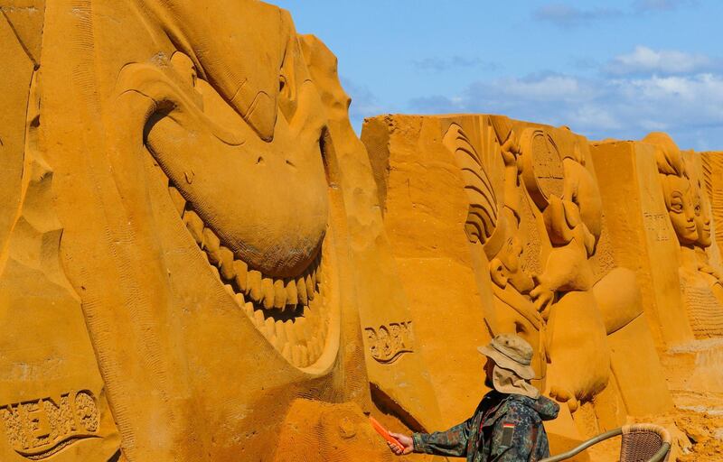 A sand carver works on a 'Finding Nemo' sculpture. Yves Herman / Reuters