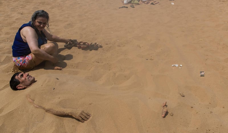 A Turkish man takes a sand bath at Kisirkaya Beach in the Black Sea coast during warm weather, amid the ongoing pandemic in Istanbul, Turkey.  EPA