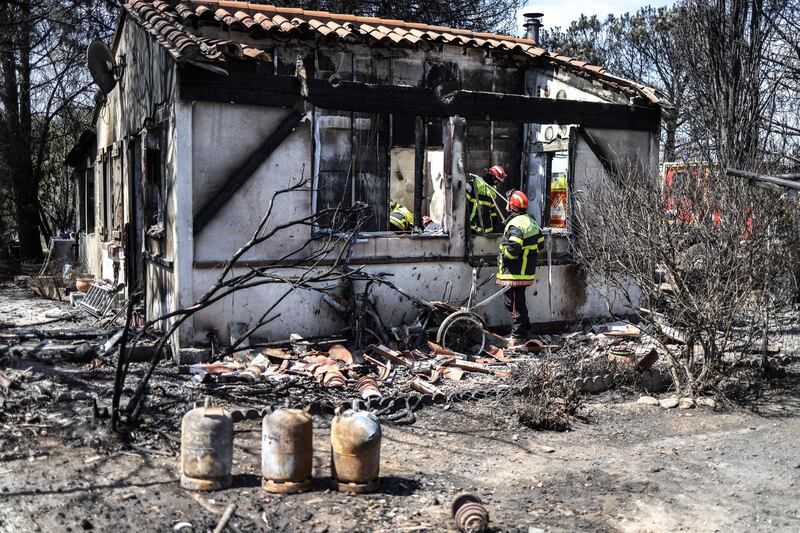 French firefighters survey a house destroyed by wildfire in Saint-Andre, near Argeles-sur-Mer. All photos: AFP