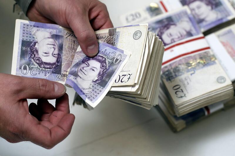 An employee manually counts 20 pound sterling banknotes in this arranged photograph inside a Travelex store, operated by Travelex Holdings Ltd., in London, U.K., on Friday, Sept. 12, 2014. The pound, already suffering its worst month in more than a year, has the potential to tumble 10 percent should the Scots vote for independence from the U.K., according to economists surveyed by Bloomberg. Photographer: Matthew Lloyd/Bloomberg