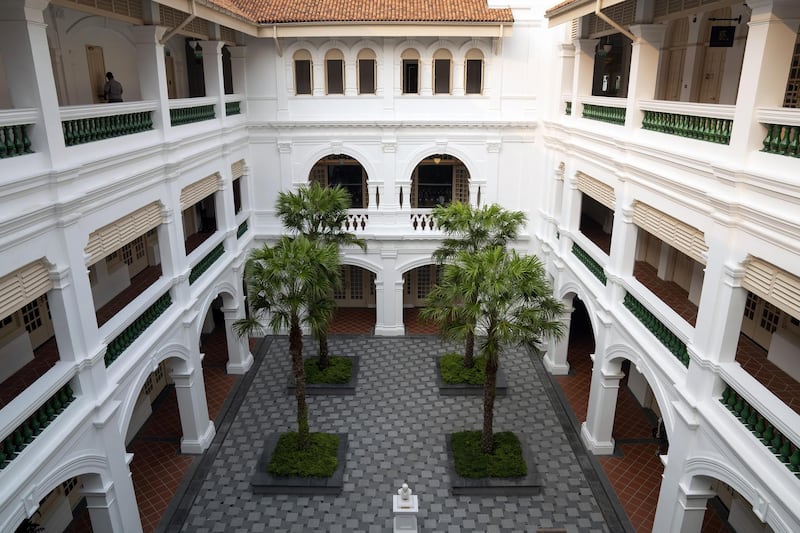Palm trees stand in a courtyard at the Raffles Hotel. Bloomberg