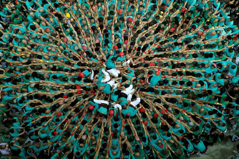 Members of group 'Castellers de Vilafranca' fold down after forming a human tower called 'castell' during a biannual human tower competition in Tarragona, Spain. Reuters