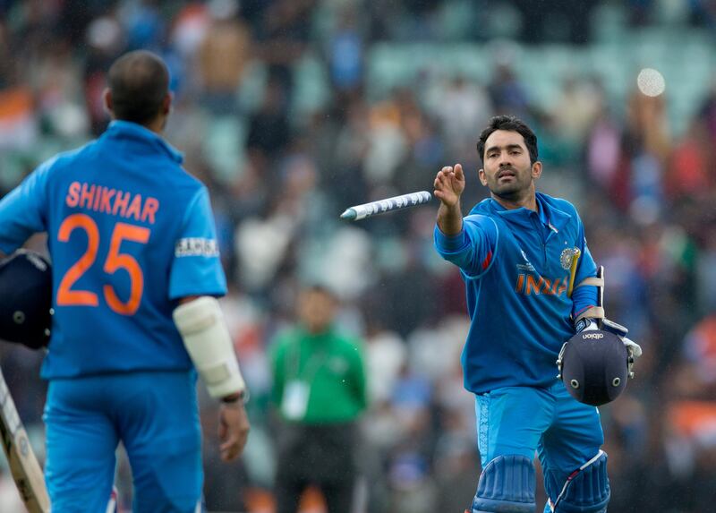 India's Dinesh Karthik, right, throws a stump to his teammate Shikhar Dhawan to keep after he scored 102 to help give their side victory runs as they walk off at the end of the ICC Champions Trophy group B cricket match between India and West Indies at The Oval cricket ground in London, Tuesday, June 11, 2013. (AP Photo/Matt Dunham) *** Local Caption ***  Britain ICC Trophy India West Indies.JPEG-017df.jpg