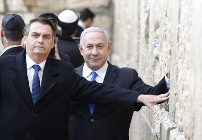 TOPSHOT - Brazilian President Jair Bolsonaro (L) and Israeli Prime Minister Benjamin Netanyahu touch the Western wall, the holiest site where Jews can pray, in the Old City of  Jerusalem on April 1, 2019. Bolsonaro arrived in Israel just ahead of the country's polls in which his ally Prime Minister Benjamin Netanyahu faces a tough re-election fight. / AFP / POOL / Menahem KAHANA
