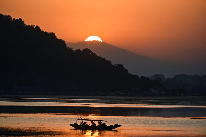 Fishermen on Dal Lake during sunset in Srinagar.  AFP