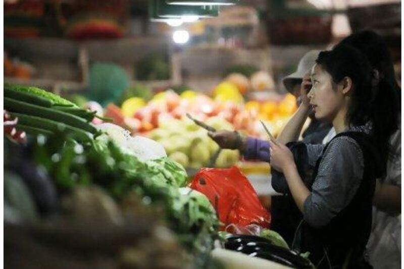 People shop for vegetables in a market in Beijing. China's food and housing costs, which includes utilities and rent, have outpaced overall inflation, soaring 11 per cent and 6.5 per cent respectively in the first quarter, increasing pressure on households already battling to make ends meet. Peter Parks / AFP Photo