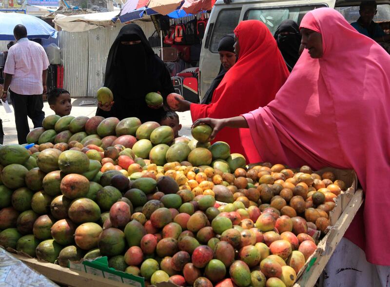 Women buy ripe mangoes and other fruits at a stall in Somalia's capital Mogadishu as Muslims prepare for the fasting month of Ramadan, the holiest month in the Islamic calendar, July 8, 2013. REUTERS/Feisal Omar (SOMALIA - Tags: FOOD SOCIETY RELIGION) *** Local Caption ***  AFR03_SOMALIA_0708_11.JPG