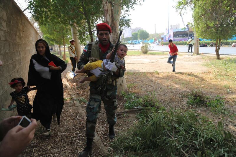 An Iranian soldier carries a child at the site of an attack on a military parade in the southwestern Iranian city of Ahvaz. AFP