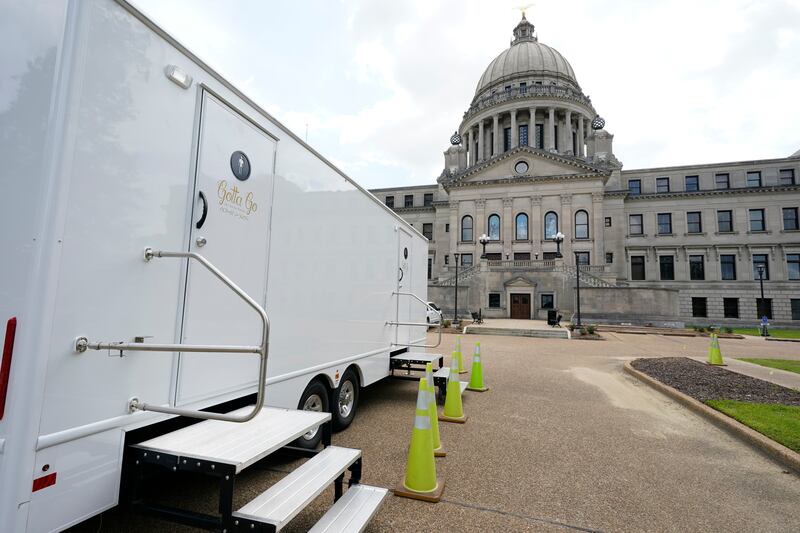 The Mississippi State Capitol dome looms over portable toilets set up in the driveway in Jackson, Mississippi. AP