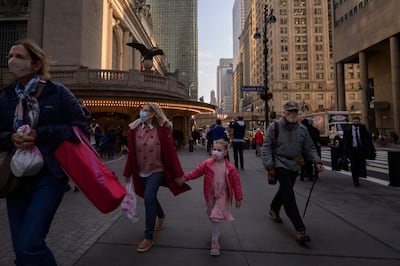 A family wearing face masks walk on a street in New York on December 6.  AFP