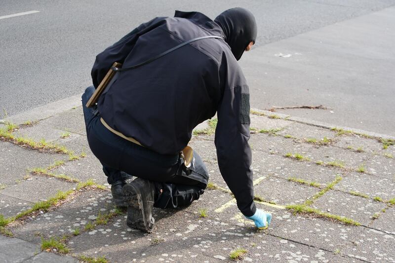 A police officer marks the ground with chalk outside the Al-Irschad association building in Berlin  EPA