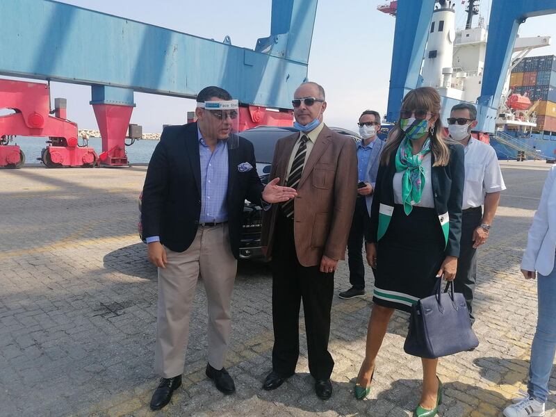 Egyptian Ambassador Yasser Elwi, left, chats with Dany Gedeon, director general of Lebanon's industry ministry, centre, as they wait with other officials to receive a shipment of glass from Egypt at Beirut port on August 28, 2020. Sunniva Rose for The National