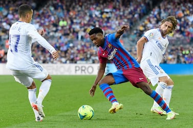 Barcelona's Spanish midfielder Ansu Fati (C) vies with Real Madrid's Spanish forward Lucas Vazquez (L) and Real Madrid's Croatian midfielder Luka Modric during the Spanish League football match between FC Barcelona and Real Madrid CF at the Camp Nou stadium in Barcelona on October 24, 2021.  (Photo by Josep LAGO  /  AFP)