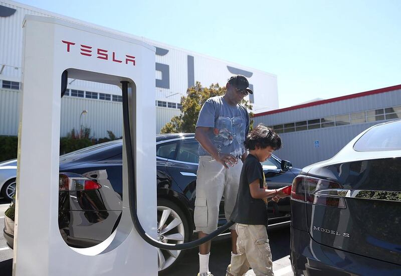 A child plugs a supercharger into a Model S sedan outside of Tesla’s California facility. The superchargers allow owners of the Tesla Model S to charge their vehicles in 20 to 30 minutes for free. Justin Sullivan / Getty Images / AFP