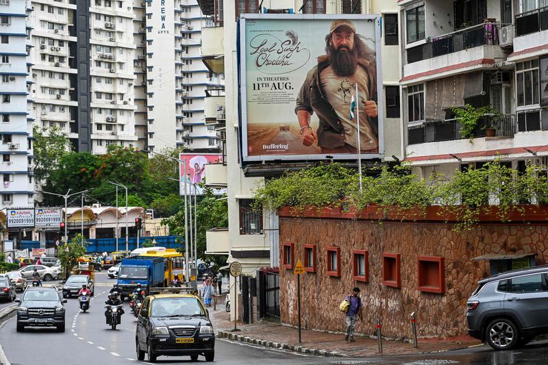 Vehicles drive past a poster of 'Laal Singh Chaddha' in Mumbai. AFP