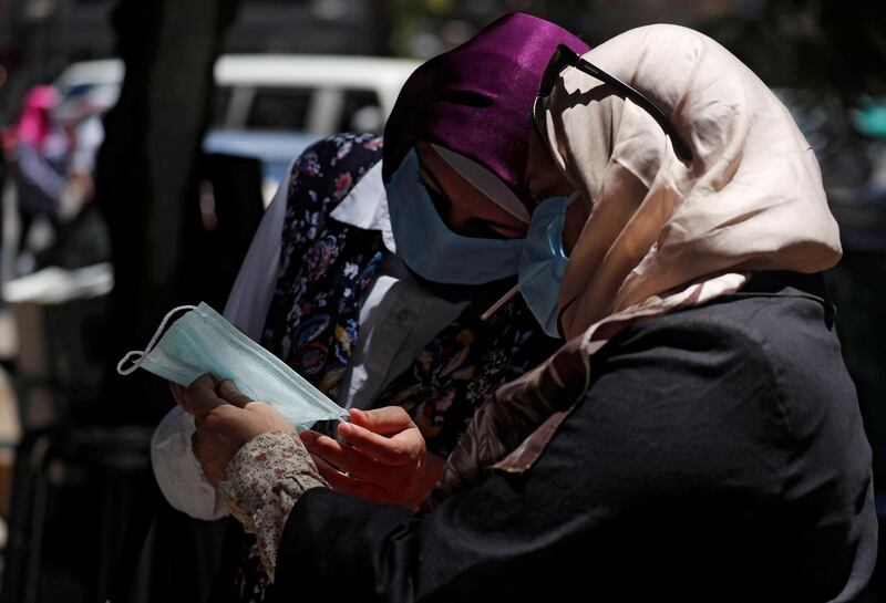 Women wearing face masks designed to prevent the spread of the new coronavirus disease (COVID-19) check a mask in front of a medical supplies shop in downtown Cairo, after Egypt's government made masks mandatory in public places and on public transport, in Cairo, Egypt May 31, 2020. REUTERS/Amr Abdallah Dalsh