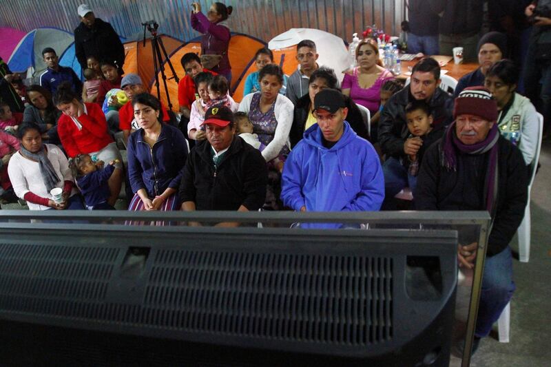 Migrants, part of a caravan of thousands from Central America trying to reach the United States, watch Donald Trump's televised address to the nation, at a shelter in Tijuana, Mexico. Reuters