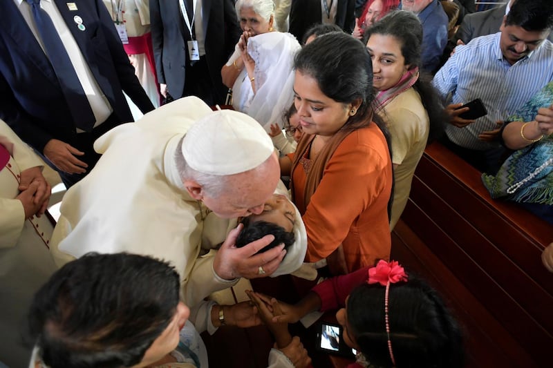 Pope Francis kisses a child during his visit to St Joseph's Cathedral in Abu Dhabi. Reuters