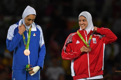 Kimia Alizadeh Zenoorin of Iran and Hedaya Wahba of Egypt celebrate on the podium after the Women's - 57kg Bronze Medal Taekwondo contest at the 2016 Rio Olympics, on August 18, 2016 in Rio de Janeiro, Brazil. Getty Images