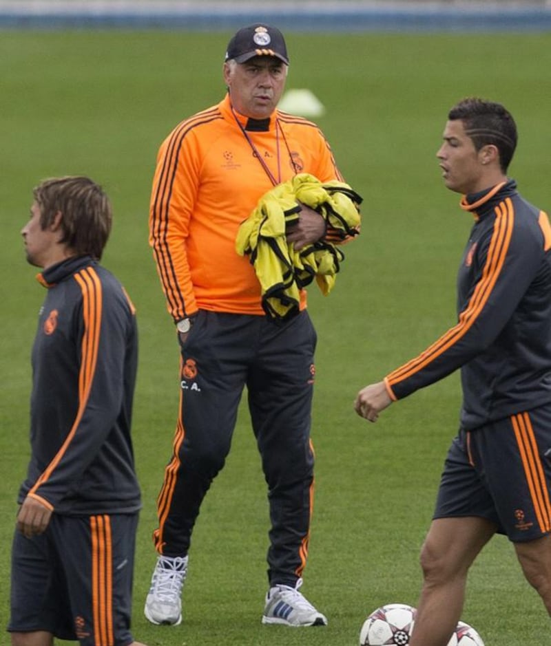 Real's coach Carlo Ancelotti, background watches as Angel Di Maria, left,  Gareth Bale, second left, Fabio Coentrao, centre and Cristiano Ronaldo walk past during a training session in Madrid, Spain, Tuesday Oct. 22, 2013. Real Madrid will play Juventus Wednesday in a Group B the Champions League soccer match.  (AP Photo/Paul White)